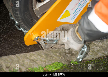 Wheel clamping of untaxed vehicles is becoming more common with the paper tax disc display being abolished and car tax needing to be paid online. Stock Photo