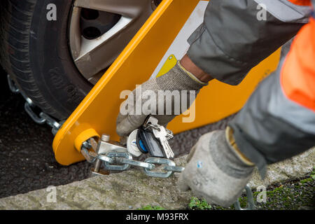 Wheel clamping of untaxed vehicles is becoming more common with the paper tax disc display being abolished and car tax needing to be paid online. Stock Photo