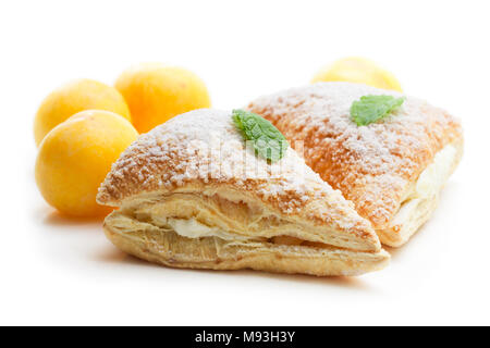 Freshly  baked plum turnovers with white cream isolated on white Stock Photo