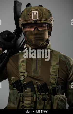 Soldier's picture in camouflage with gun in studio Stock Photo