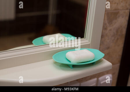 Yellow soap on a blue soap dish isolated on a white background Stock Photo