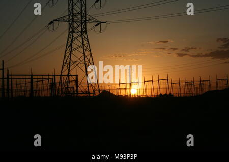 Sun setting behind power lines Stock Photo