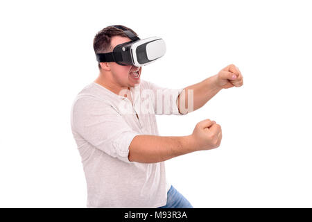 A man in virtual reality glasses is driving an invisible car playing a game or a simulator. Stock Photo