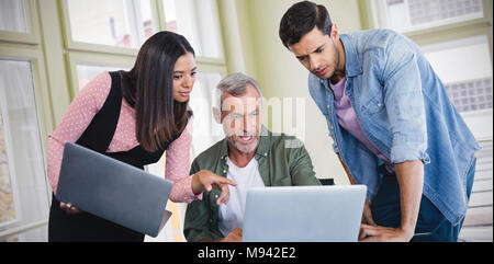 Composite image of business people discussing over laptop Stock Photo