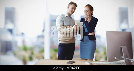 Composite image of colleagues discussing over tablet while standing at table Stock Photo