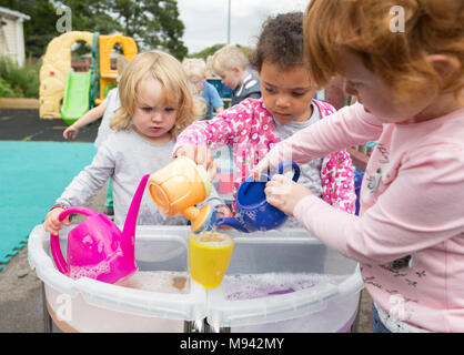 Nursery school children playing in a playground in Warwickshire, UK Stock Photo