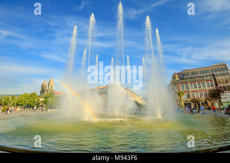 Braga, Portugal - August 12, 2017: rainbow in the middle of fountains at Medieval Republic Square or Praca da Republica known as Arcade. Braga urban cityscape, one of the oldest cities of Portugal. Stock Photo