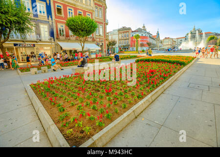 Braga, Portugal - August 12, 2017: flower beds and tourist walking in Avenida da Liberdade, one of the main avenues of Braga, crossing Praca da Republica known as Arcade with her fountain. Stock Photo