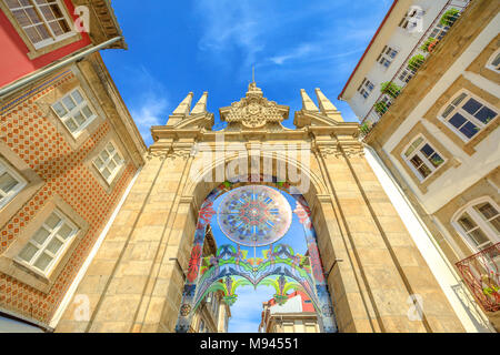 Braga, Portugal - August 12, 2017: Perspective view of Arco da Porta Nova, looking east along Rua Dom Diogo de Sousa. Arch of the New Gate in Baroque style city gate, part of the Braga city walls. Stock Photo