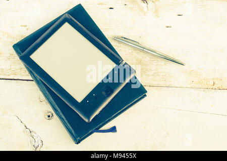 Black ereader with notebook in leather cover and ink pen on vintage old rustic wooden table. Blank E-book reader. New technologies in education. Back  Stock Photo