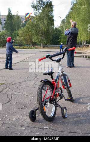 Jartcevo, Russia - August 01, 2010: Grandfather and grandson left the bike and launched a kite Stock Photo