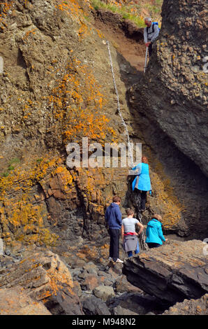 A group of people do  the rocky coastal chain walk in Elie, Fife Stock Photo