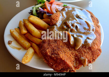 Schnitzel with salad, mushroom sauce and french fries Stock Photo