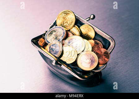 Wallet filled with many coins Stock Photo
