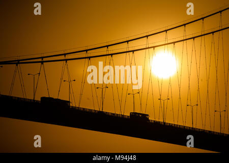 A golden sun sets behind the cables of the Bosphorus bridge, Istanbul, Turkey Stock Photo
