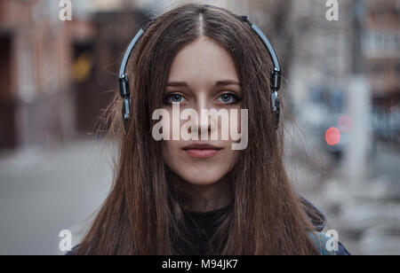 Girl hipster in headphones looking at camera, full face portrait Stock Photo