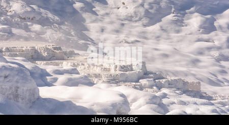 Snow coats a mineral cascade in a wintery Mammoth Hot Springs at Yellowstone National Park. Stock Photo