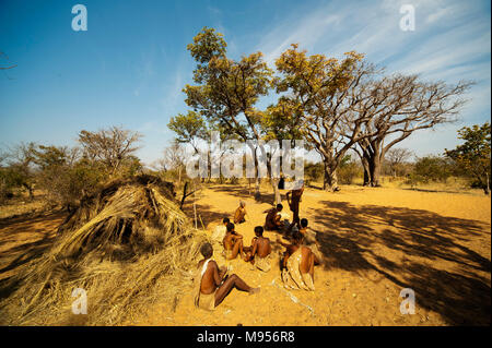 Ju/'Hoansi or San bushmen in daily activities making bow and arrows at their village, Grashoek, Namibia Stock Photo