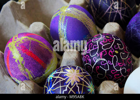 An egg carton holding decorated easter eggs. Stock Photo