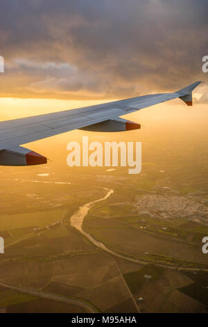 View from an airplane window during landing to the airplane wing with aerial view of the Andalusian landscape in Spain during evening sunset