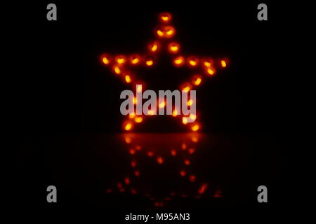 Decorative star with lamps on a black background. Stock Photo