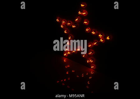 Decorative star with lamps on a black background. Stock Photo