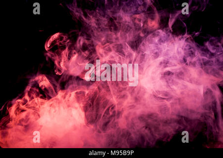Dense red multicolored smoke on a black isolated background. Background of smoke vape Stock Photo