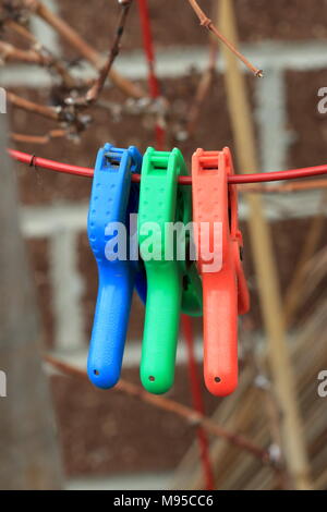Close up of colourful clamps on metal wire Stock Photo