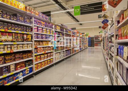 Biscuits and confectionery on full shelves in an Asda supermarket. Stock Photo