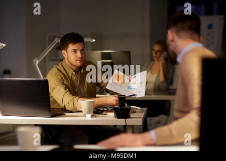 colleagues discussing project late in office Stock Photo