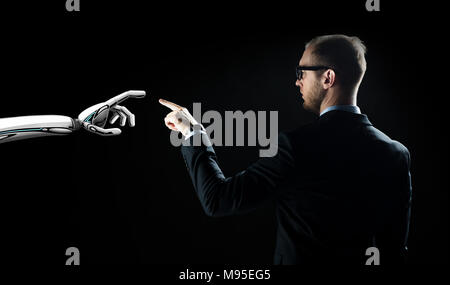 robot and human hand flash light over black Stock Photo