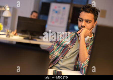 creative man with computer working at night office Stock Photo