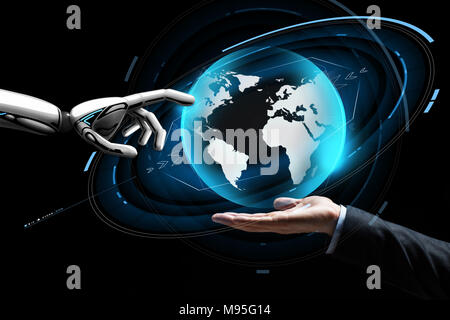 human and robot hand with virtual earth hologram Stock Photo