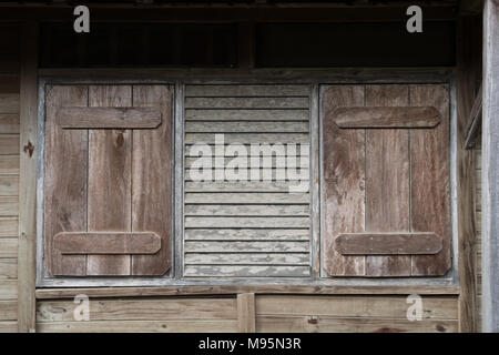 window with closed shutters - wooden building exterior with closed shutter - Stock Photo