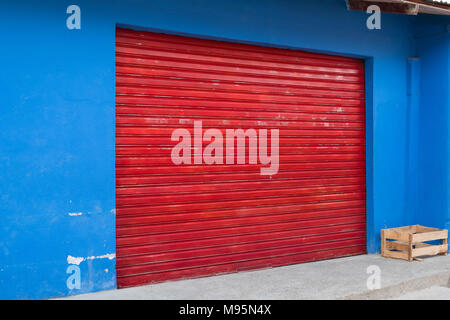 shop exterior with closed red shutter - closed storefront - Stock Photo