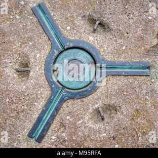 Ordnance Survey triangulation station or trig point showing three-armed bronze plate with grooves for mounting a theodolite - Exmoor Somerset UK Stock Photo