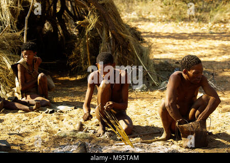 Ju/'Hoansi or San bushmen in daily activities making bow and arrows at their village, Grashoek, Namibia Stock Photo