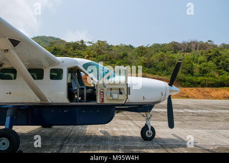 Small  propeller airplane with open cockpit door on runway Stock Photo