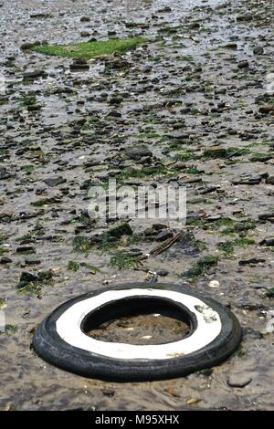 Discarded whitewall car tire in the sand of Bottle Beach, the western shore of Dead Horse Bay, Brooklyn, New York, USA. Stock Photo