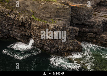 Waves crashing against rocks at Loop Head Bridges of Ross on Ireland's Atlantic coast in County Clare Stock Photo