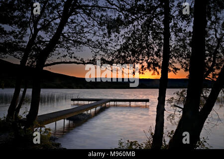 Wooden jetty on the shore of Lough Derg, County Clare, Ireland at sunset Stock Photo