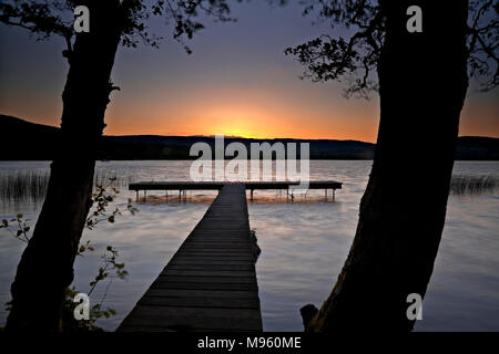 Wooden jetty on the shore of Lough Derg, County Clare, Ireland at sunset Stock Photo