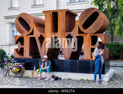 Berlin, Mitte. Hamburger Bahnhof Contemporary Art Museum garden. Rusty 'Love' sculpture and visitors to the gallery Stock Photo