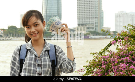 The Vietnamese girl holds in her hands and boasts five hundred thousand denominations of Vietnamese dong. Stock Photo