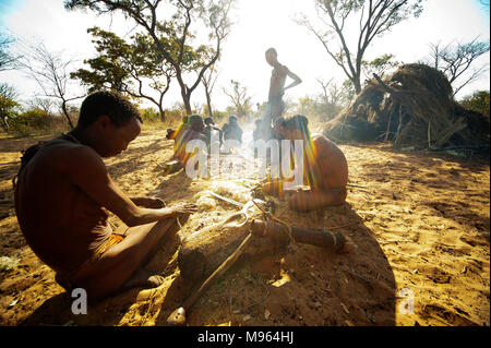 Ju/'Hoansi or San bushmen in daily activities making bow and arrows at their village, Grashoek, Namibia Stock Photo