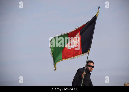 Afghan Commando beneath an Afghan national flag in Shindand Military Base, Herat province. Afghanistan’s elite military forces – the Commandos and the Special Forces are one of the key elements in the Afghan and U.S. strategy to turn the grinding fight against the Taliban and other insurgents around. These pictures show the Commandos and Special Forces during training and in the field; also right before and after an operation in the restive western Afghan province of Farah. Stock Photo