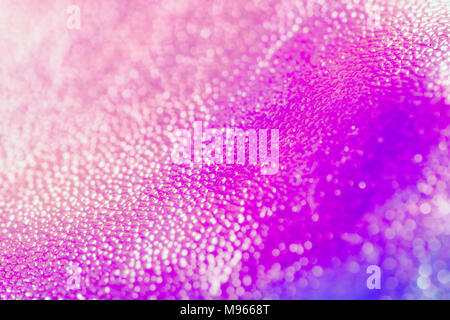 Bright shiny holographic purple and blue neon real texture. Holographic background 80s - 90s, trendy colorful texture in neon color design. Stock Photo