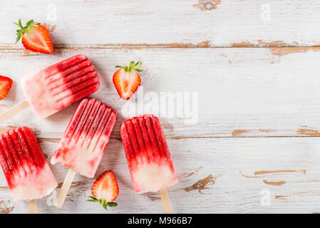 Homemade Vegan Strawberry Popsicle from Strawberry Juice and Coconut Milk on light wooden background. Summer food concept. Top view. Stock Photo