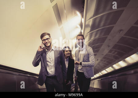 Coworkers using subway stairs together Stock Photo