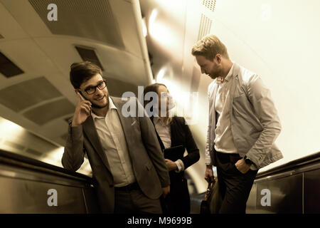 Coworkers using subway stairs together Stock Photo